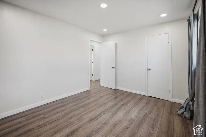 Neutral-toned interior featuring wood-finish flooring, recessed lighting, and white interior doors