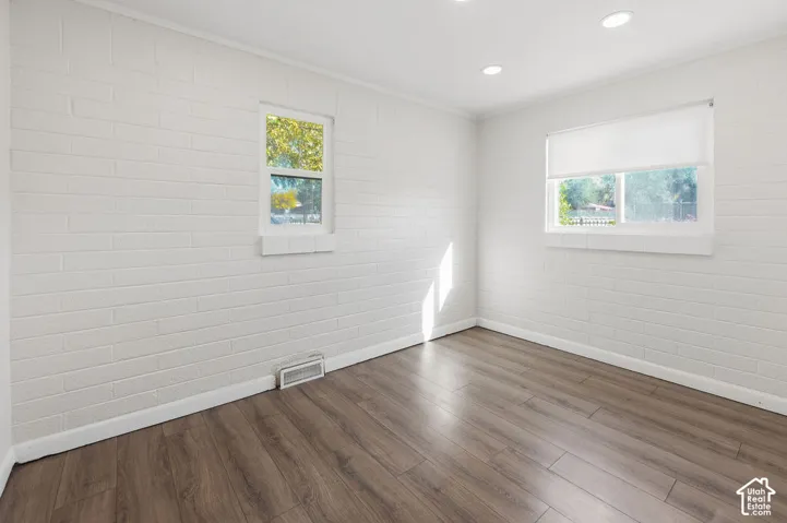 Painted brick wall finishes, wood-finish flooring, and recessed ceiling lighting