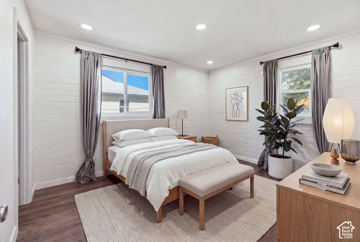 White painted masonry walls, wood-finish flooring, and recessed ceiling lighting