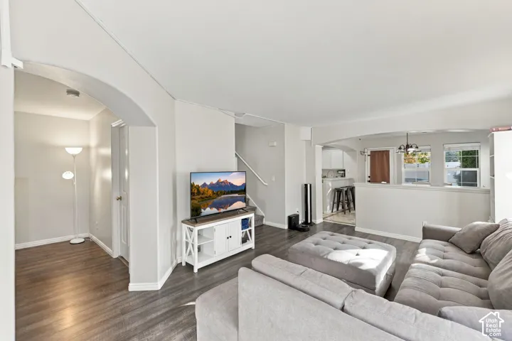 Open-concept interior featuring archway architectural detailing, wood-finish flooring, and a half-wall partition