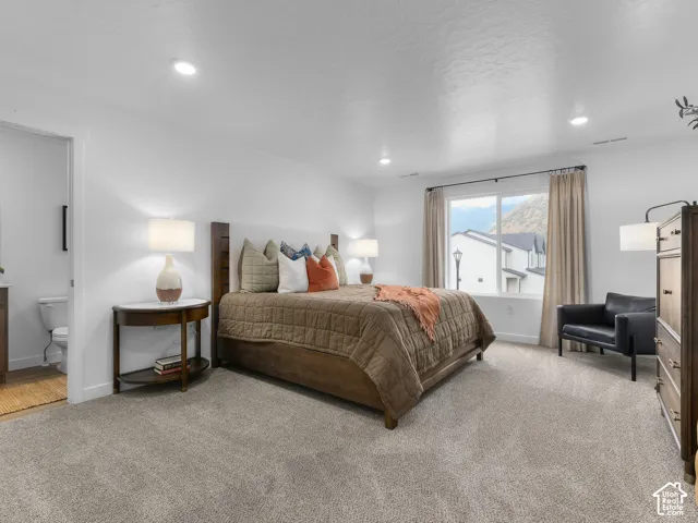 Spacious room featuring neutral carpeting, recessed ceiling lighting, and a large window with natural light