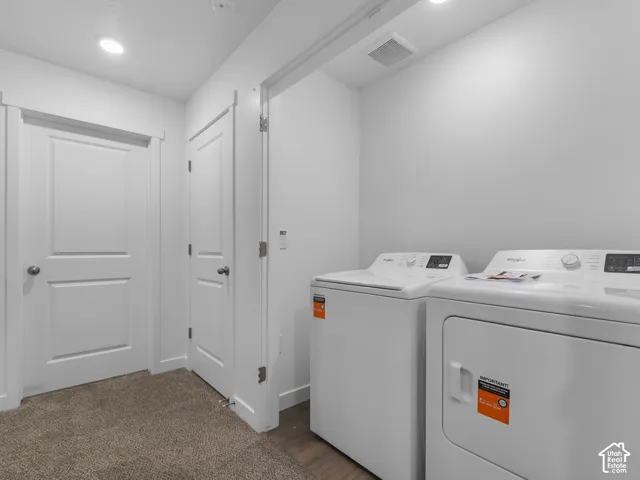 Dedicated laundry area featuring recessed lighting, neutral carpeting, and two interior doors with brushed nickel hardware