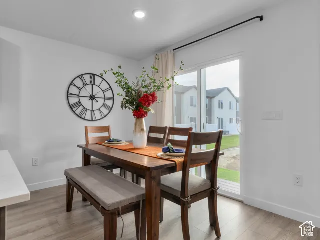 Sliding glass door with black curtain rod, recessed lighting, and wood-finish flooring