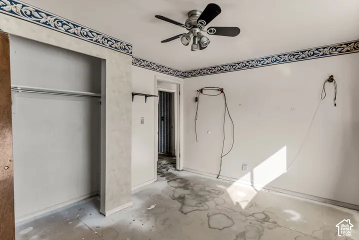 Interior room featuring a ceiling fan with integrated lighting and decorative wall border wallpaper