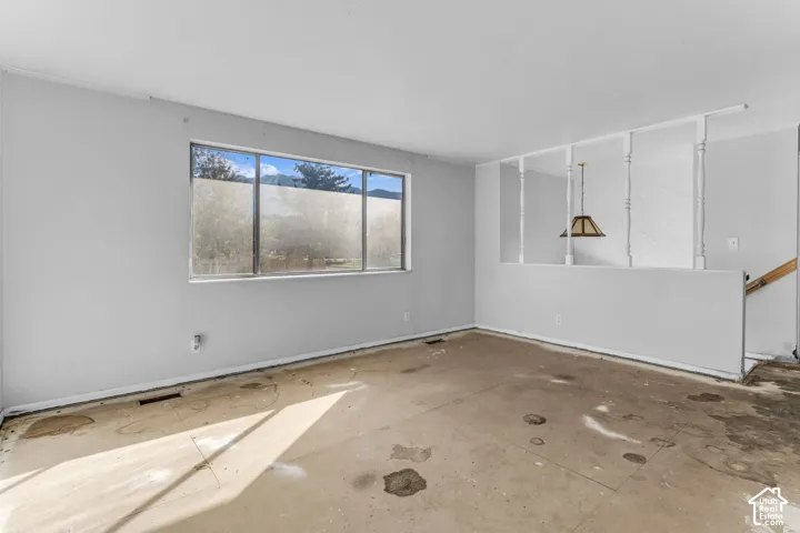 Interior space featuring a large picture window, mountain backdrop, and decorative half-wall with vertical spindles and a hanging pendant fixture