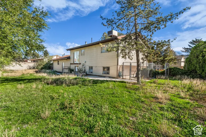 Exterior elevation featuring horizontal siding, a concrete patio, and fenced perimeter
