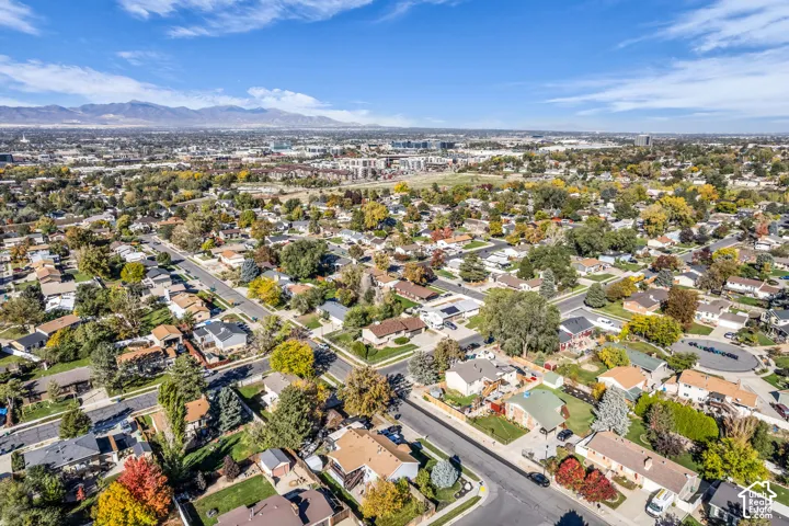 Aerial perspective of a suburban neighborhood featuring mature landscaping and a mountain range backdrop