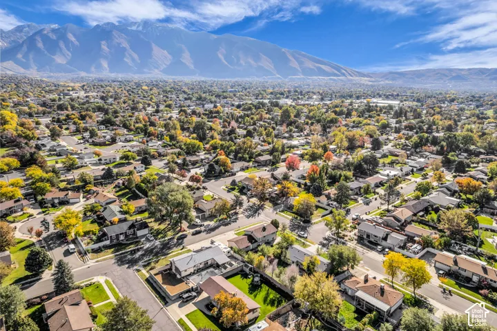 Aerial perspective featuring a residential neighborhood backdrop framed by a prominent mountain range