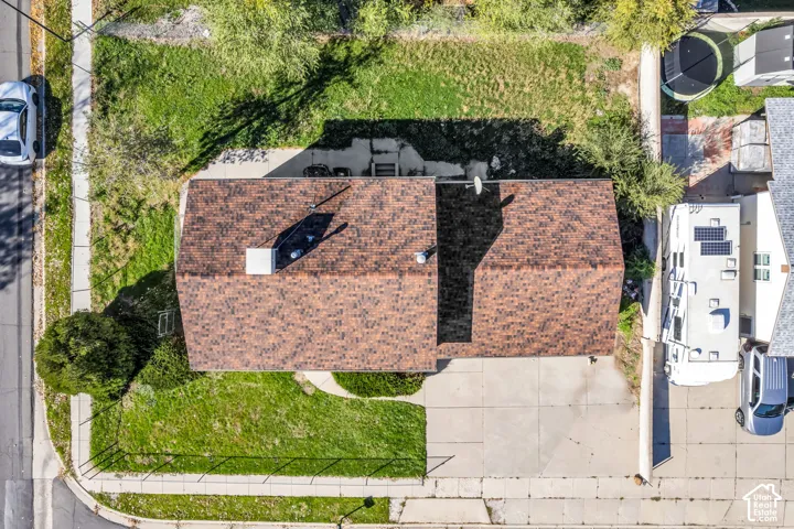 Aerial perspective featuring a multi-gabled roofline, concrete driveway, and expansive lawn area