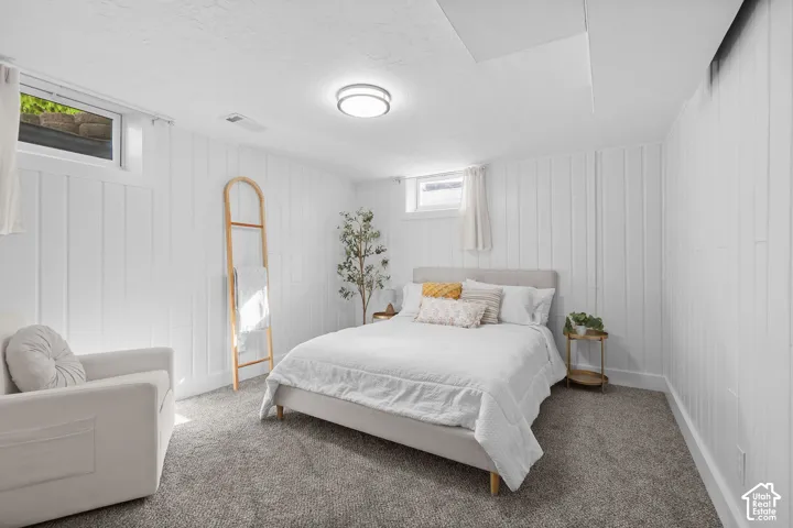 Vertical wood-paneled walls, neutral carpeting, recessed ceiling lighting, and horizontal casement windows