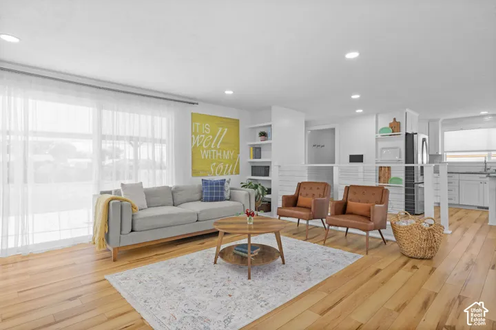 Wood-finish flooring, recessed lighting, built-in shelving, and large sliding glass doors