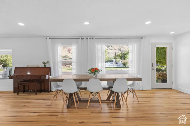 Wood-finish flooring, recessed lighting, large windows, and a glass-paneled exterior door
