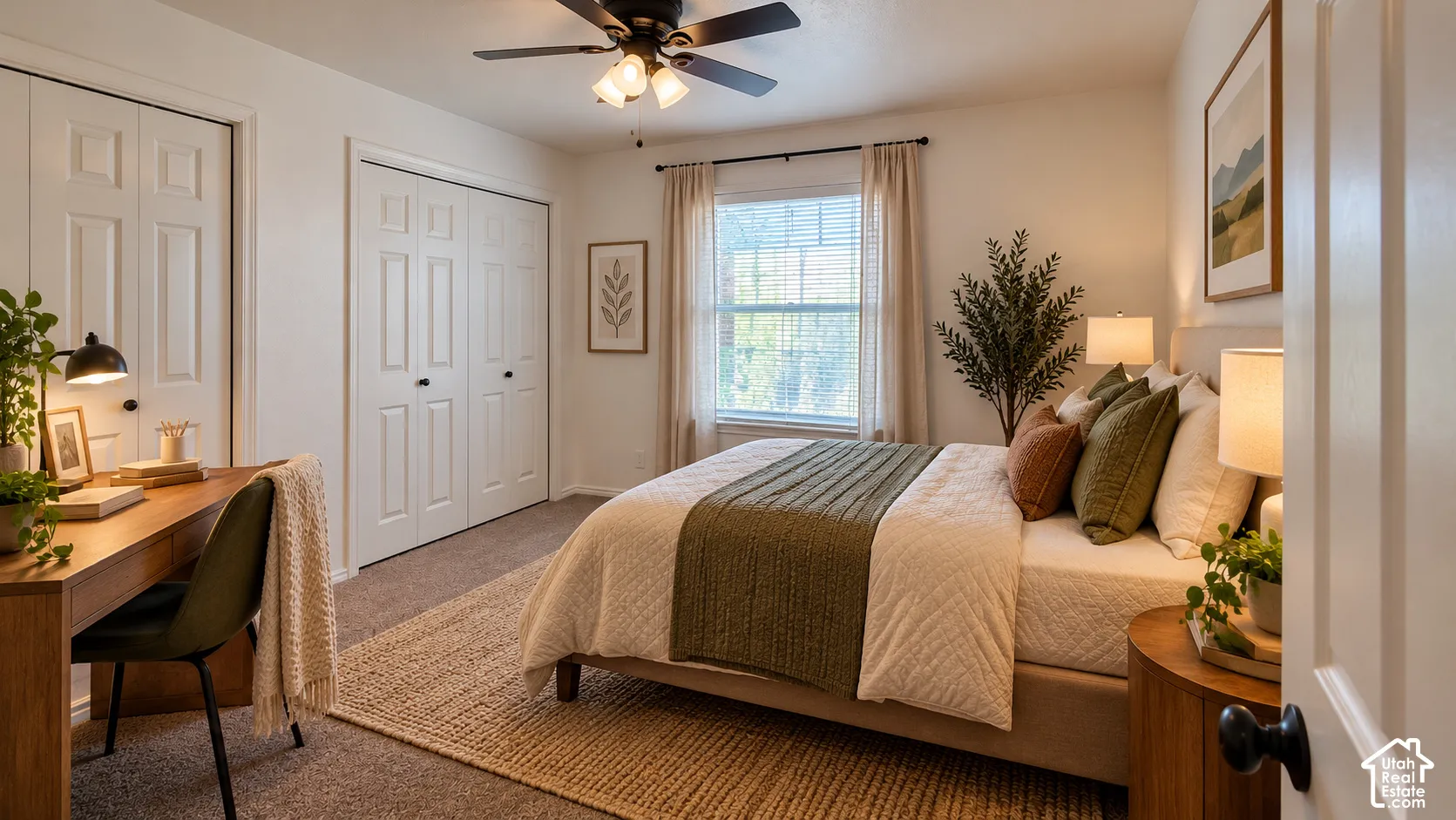 Carpeted room featuring dual-door closets with paneled detailing, a central ceiling fan with integrated lighting, and a window with horizontal blinds