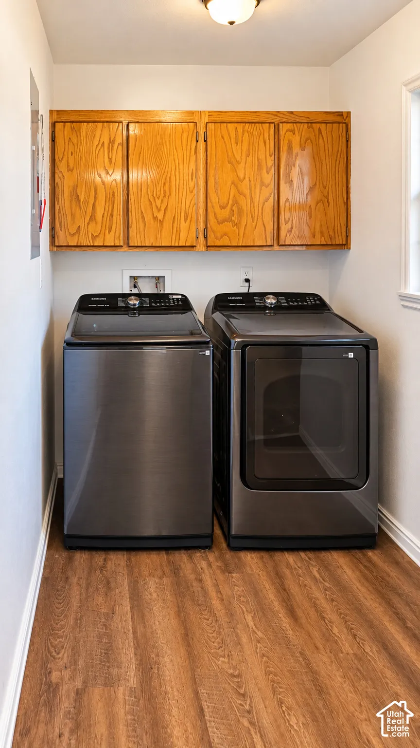 Laundry area featuring wood-finish flooring, wall-mounted wood cabinetry, and recessed ceiling lighting