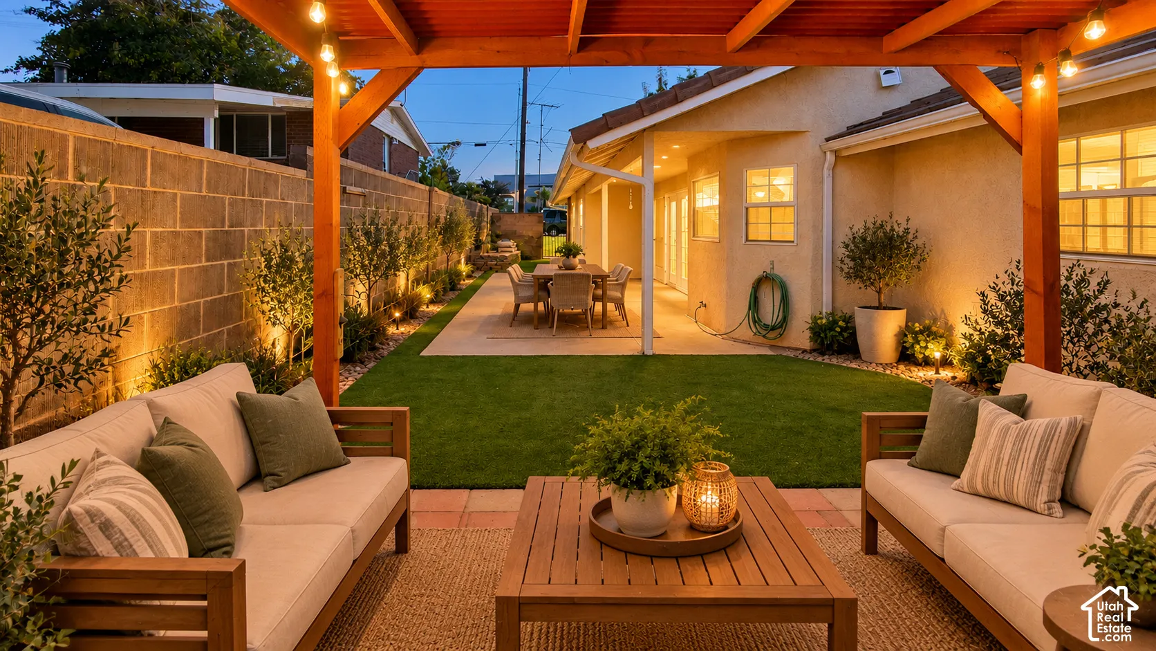 Covered wood pergola, paver patio, synthetic turf lawn, and masonry perimeter wall