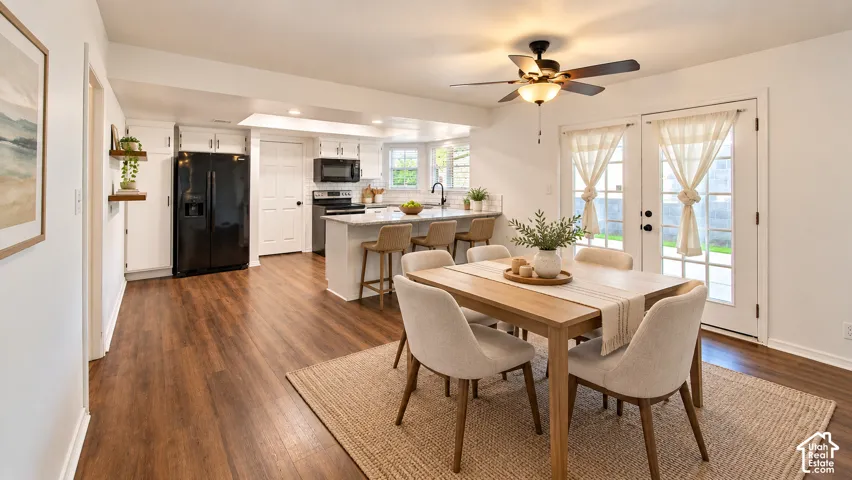 Kitchen featuring wood-finish flooring, white cabinetry, a stone-surface breakfast bar, a ceiling fan, and double glass-paned exterior doors