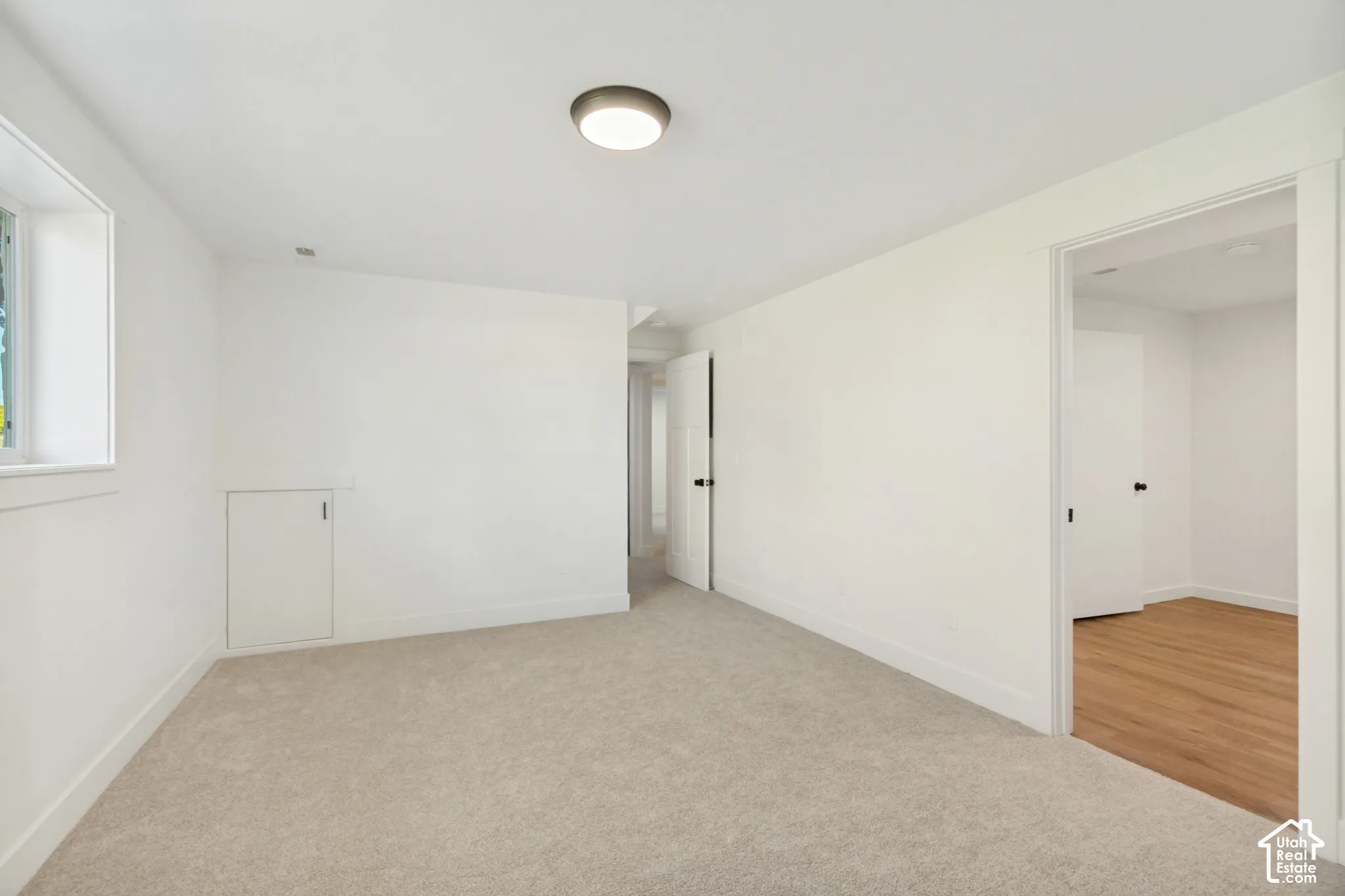 Neutral-toned carpeting, flush-mount ceiling lighting, solid-core doors, and built-in under-stair storage access