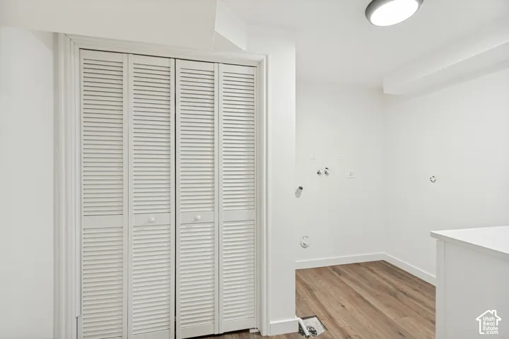 Bi-fold louvered closet doors, wood-finish flooring, and recessed ceiling lighting