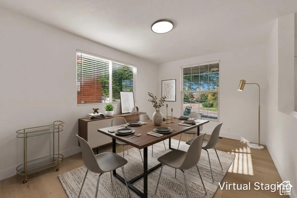 Neutral-toned interior featuring wood-finish flooring, dual windows with blinds, and a flush-mount ceiling light fixture