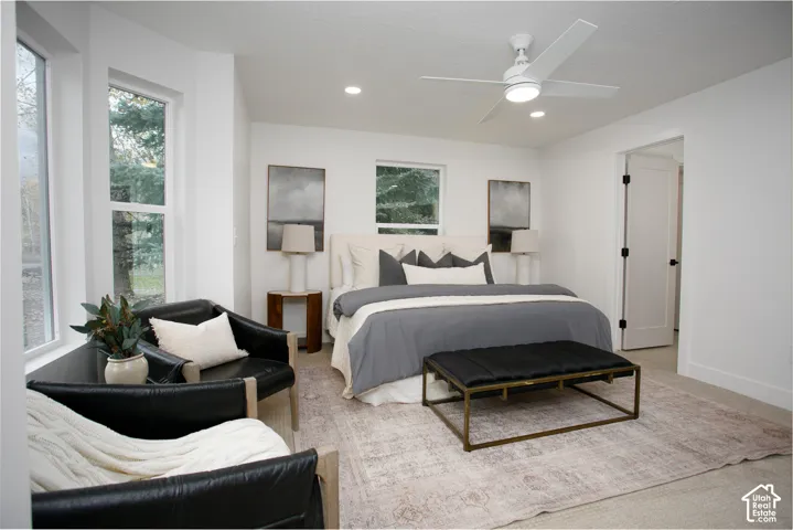 Neutral interior featuring wall-to-wall carpeting, recessed lighting, a modern ceiling fan, multiple windows, and a shaker-style interior door