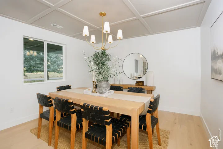 Coffered ceiling, gold-finish six-light chandelier, and light-tone wood-finish flooring