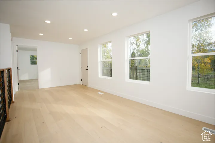 Interior space featuring wood-finish flooring, recessed lighting, and three large windows
