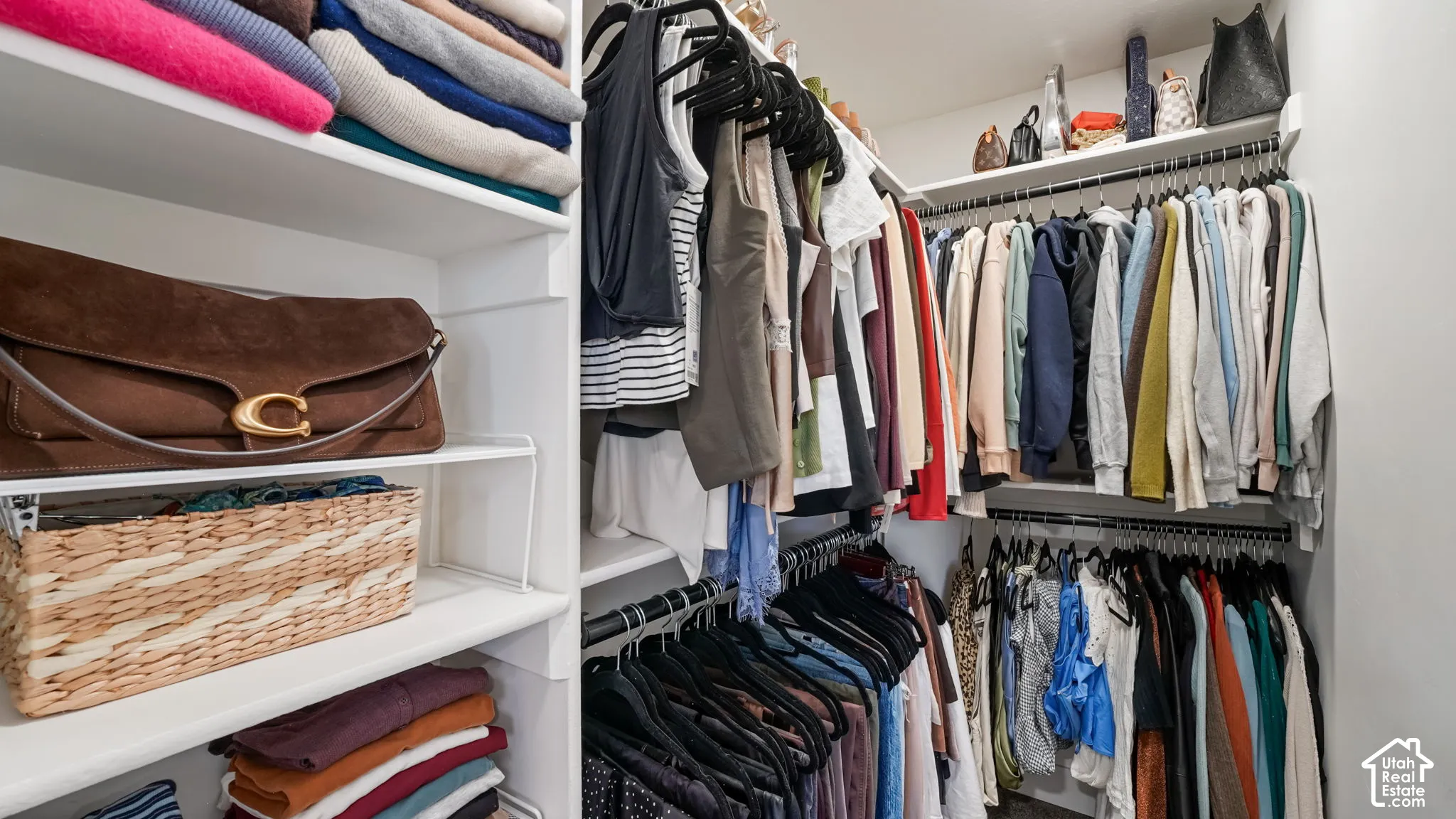 Custom storage system featuring white laminate shelving and multi-level metal hanging rods