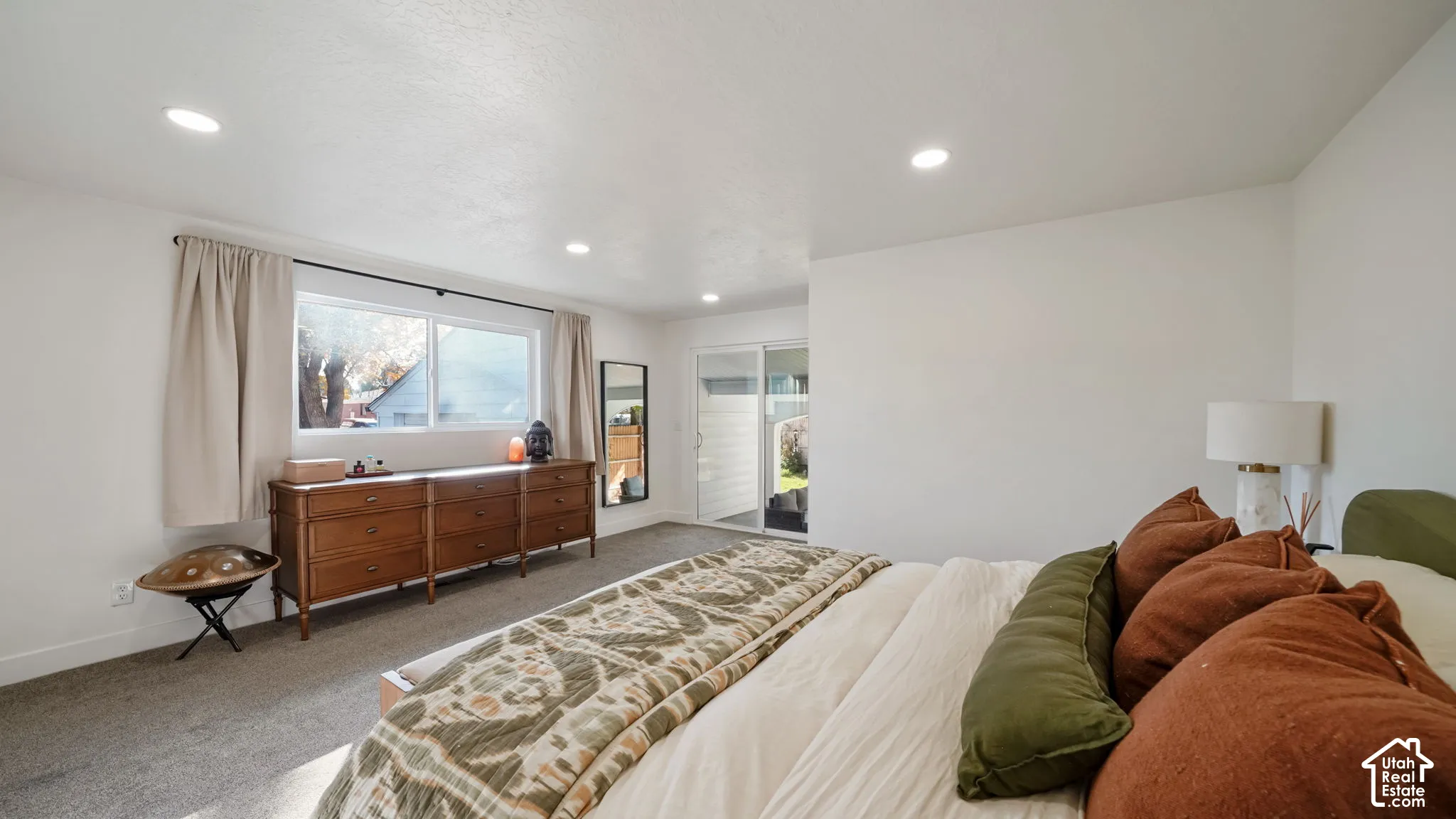 Neutral-toned wall finish, recessed ceiling lighting, wall-to-wall carpeting, large window with natural light, and sliding glass door
