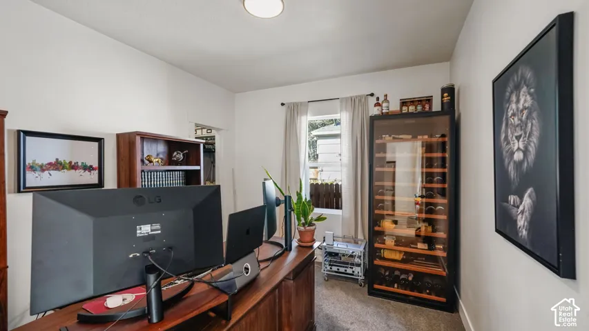 Interior room featuring neutral wall paint, carpeted flooring, and a single-pane window with curtain hardware