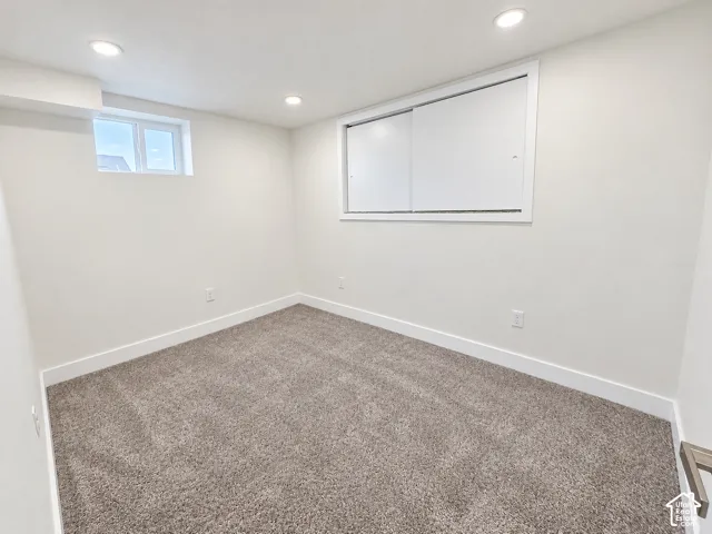 Neutral-toned room featuring wall-to-wall carpeting, recessed ceiling lighting, and sliding window treatments