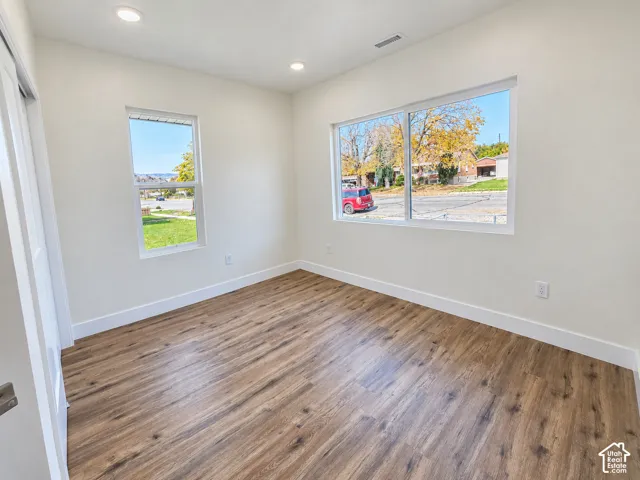 Interior room featuring wood-finish flooring, recessed lighting, and multiple windows
