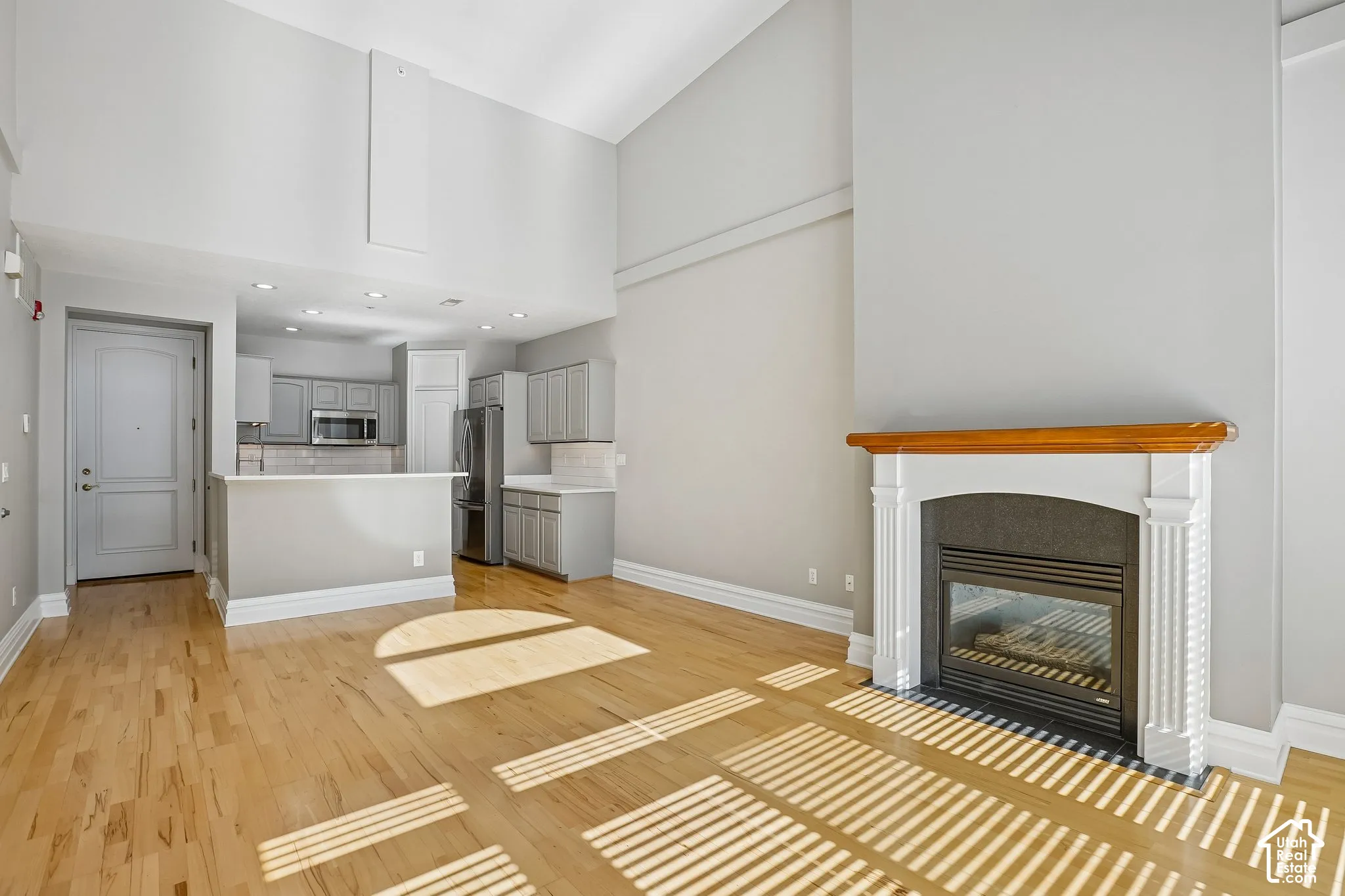 Vaulted ceilings, wood-finish flooring, and a fireplace with a traditional mantel