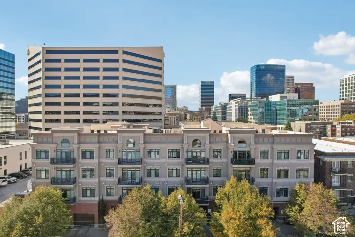 Multi-story mixed-material facade featuring brick base, arched architectural detailing, and wrought iron balconies