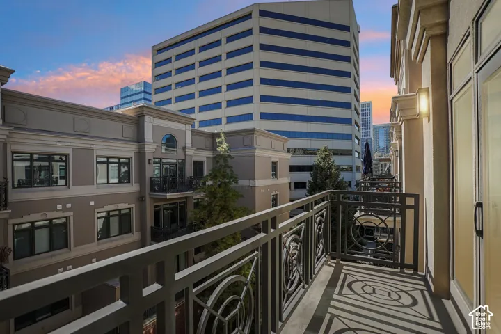 Covered balcony featuring geometric metal railings, concrete flooring, and an attached wall-mounted light fixture