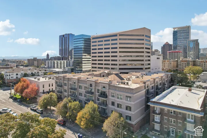 Mid-rise residential building featuring stucco exterior, arched architectural detailing, and private balconies