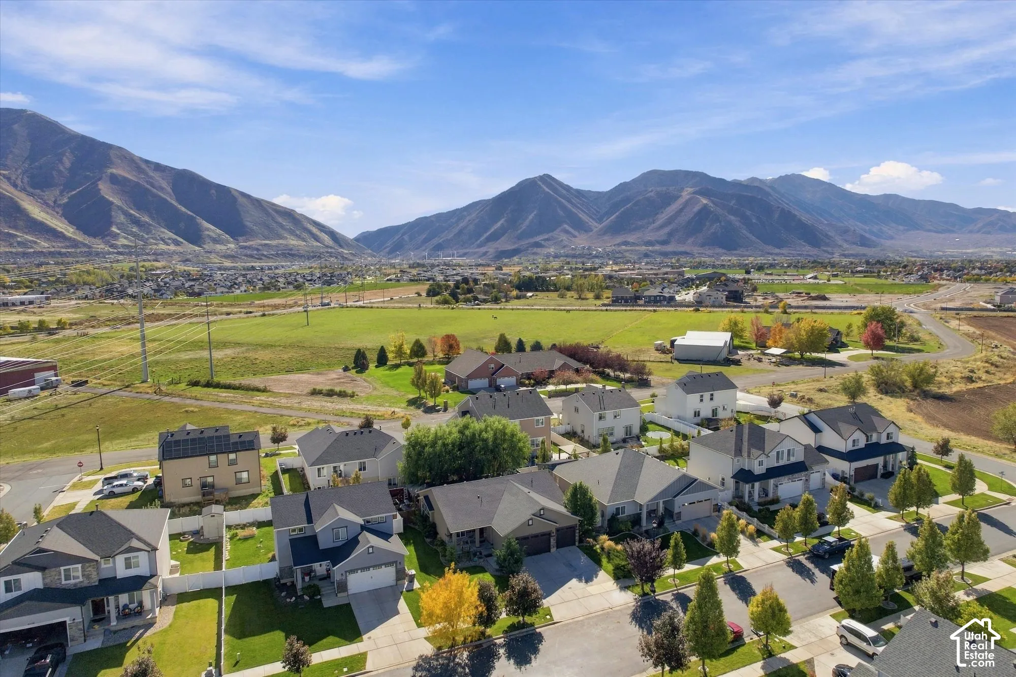 Aerial perspective featuring residential lots with manicured lawns and mountain backdrops