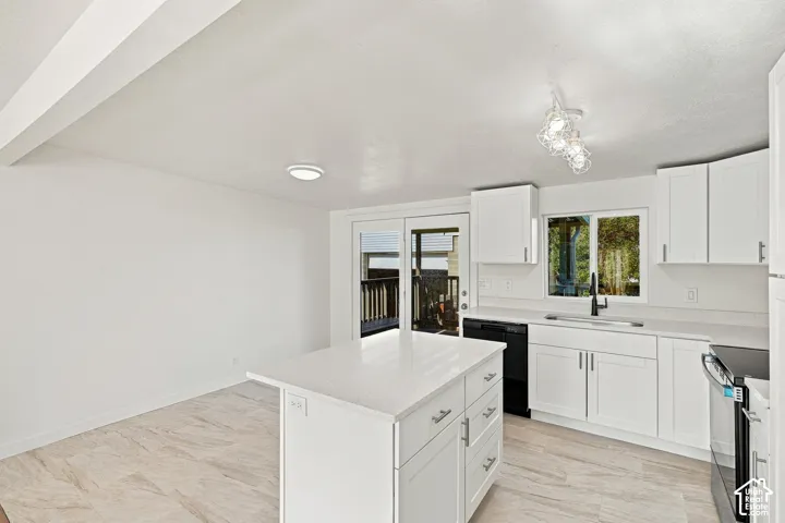 Kitchen featuring white shaker-style cabinetry, a central island with a quartz countertop, wood-finish flooring, and a glass-paneled exterior door