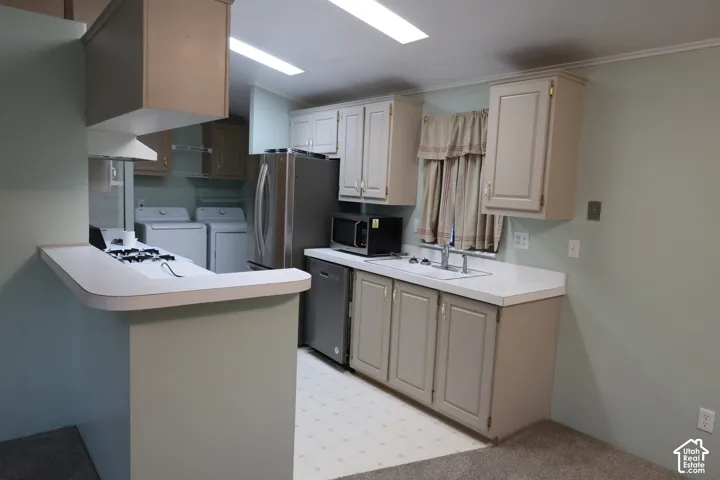 Kitchen featuring cabinetry with neutral-finish doors, solid-surface countertops, integrated stainless steel appliances, and a breakfast bar