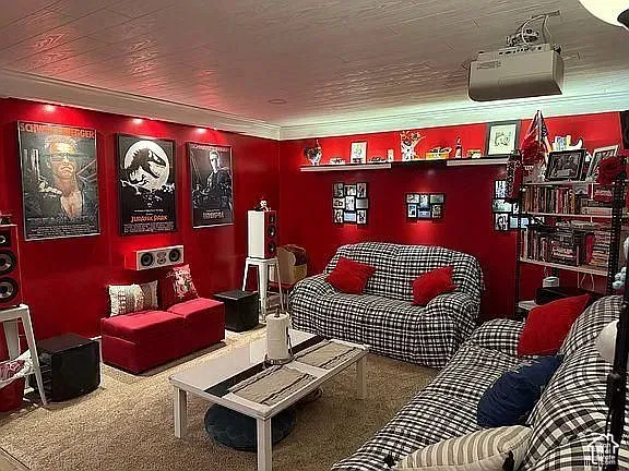 Media room featuring a ceiling-mounted digital projector, recessed lighting, and wall-mounted shelving