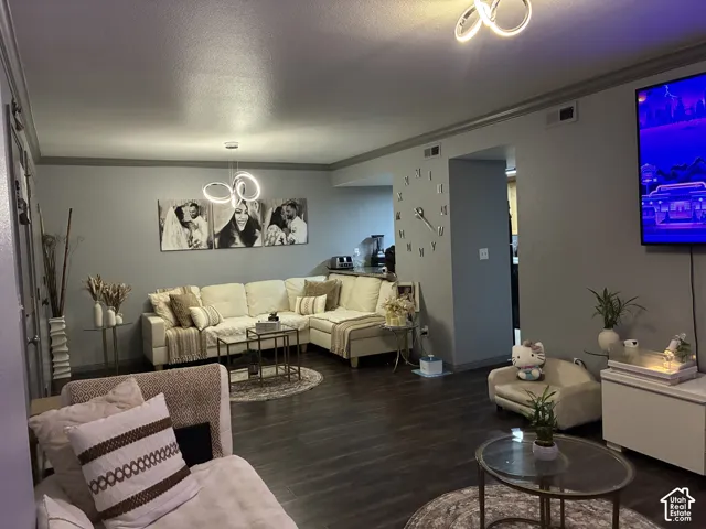 Living space featuring dark wood-finish flooring, recessed lighting, and contemporary dual circular chandeliers