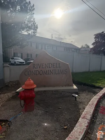 Custom stone monument signage featuring metal lettering, concrete perimeter wall, and manicured green space
