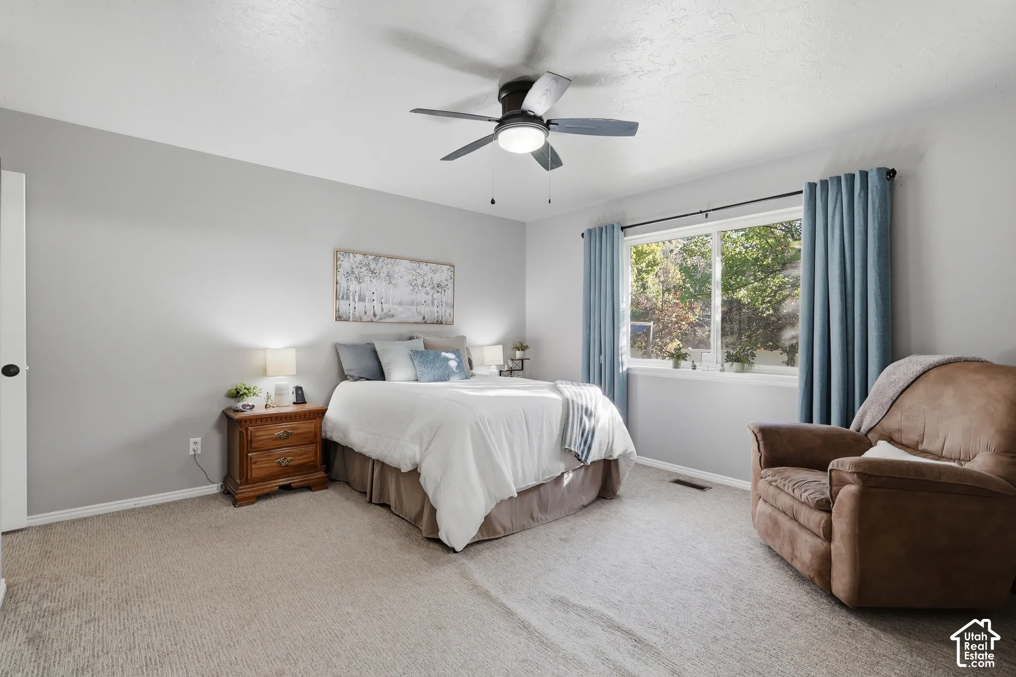 Bedroom featuring neutral wall paint, wall-to-wall carpeting, and a central ceiling fan with integrated lighting