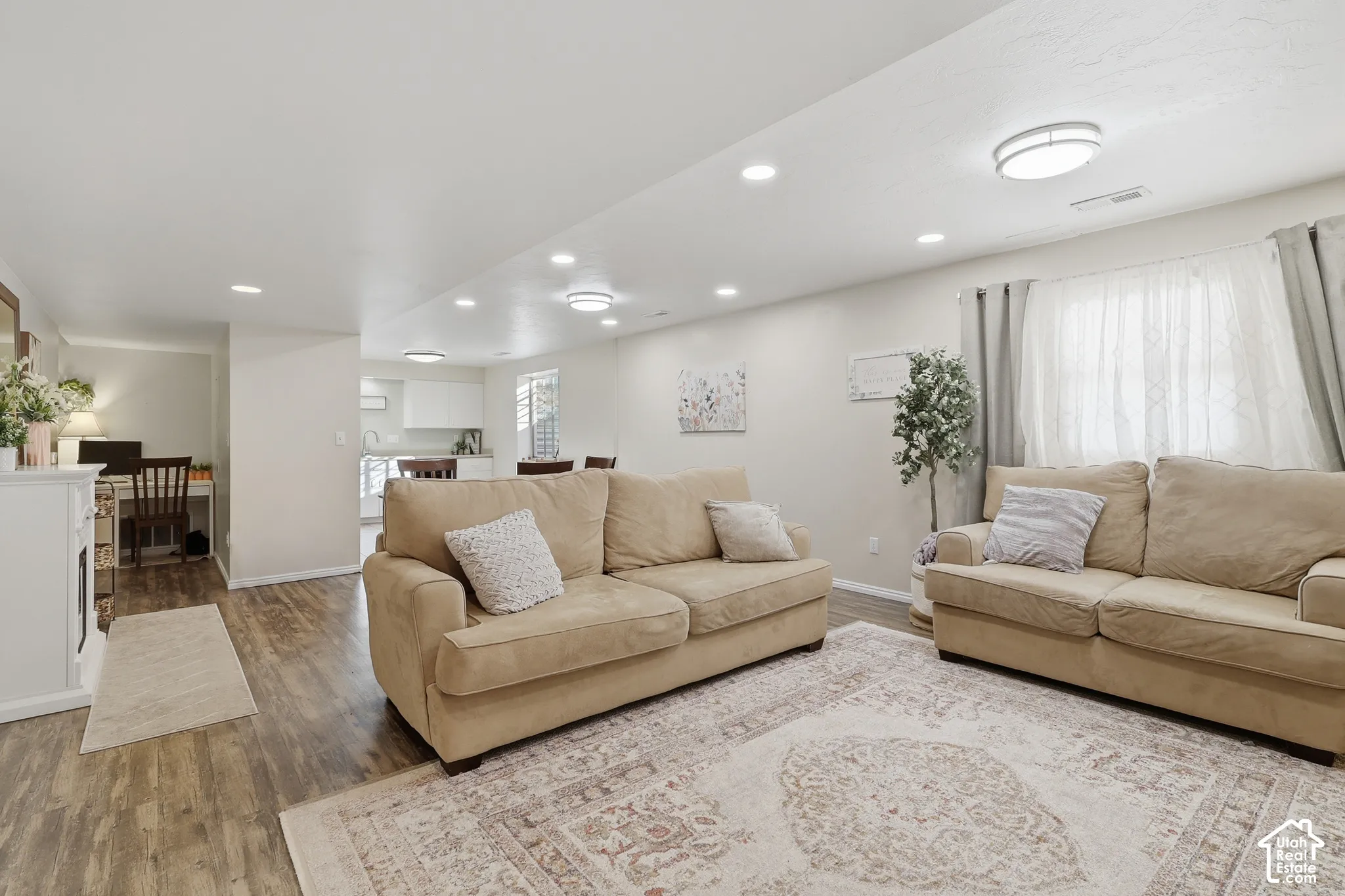Neutral-toned interior featuring wood-finish flooring, recessed lighting, and a built-in decorative fireplace