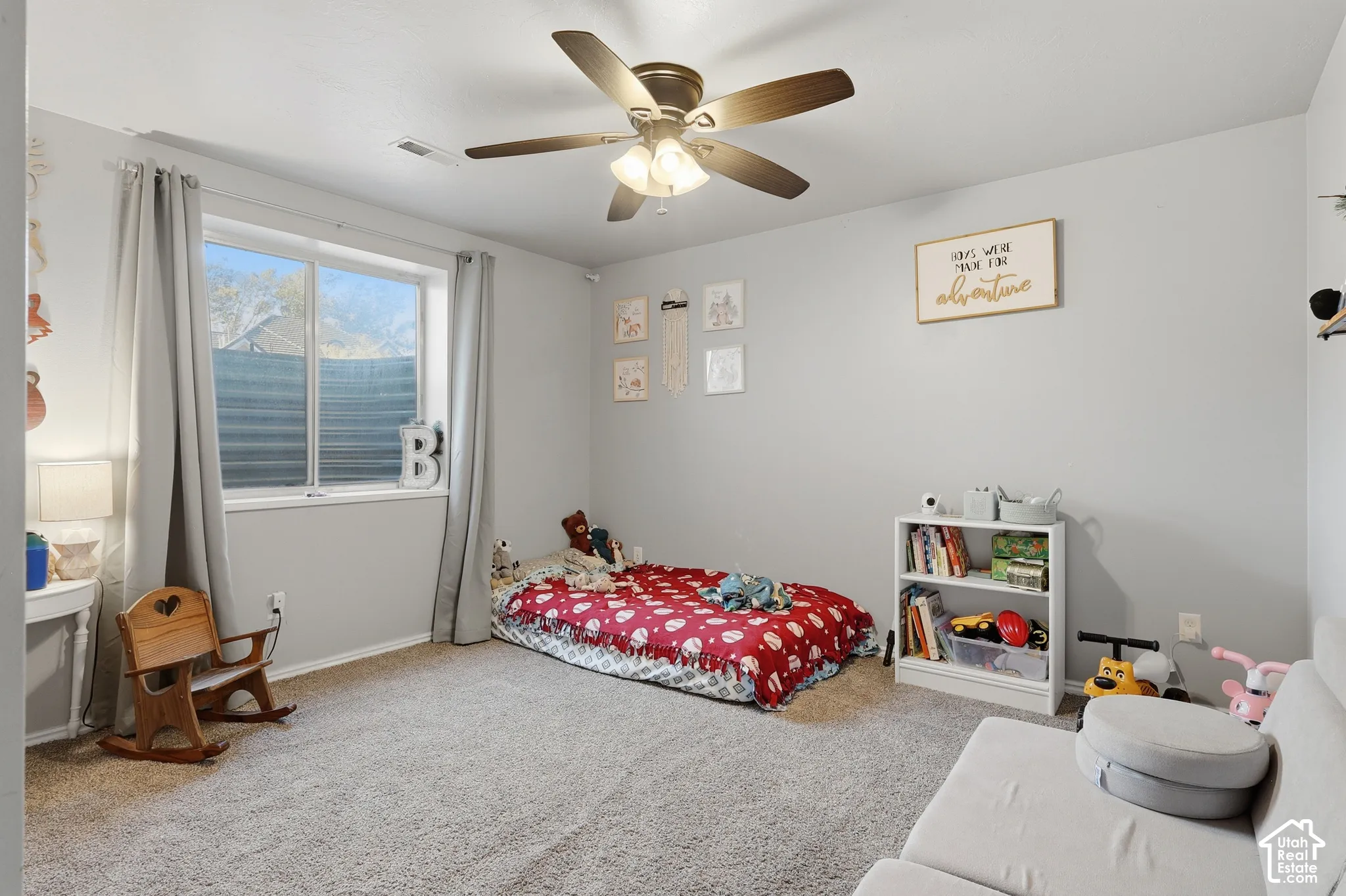 Neutral-toned interior space featuring wall-to-wall carpeting and a ceiling fan with integrated lighting