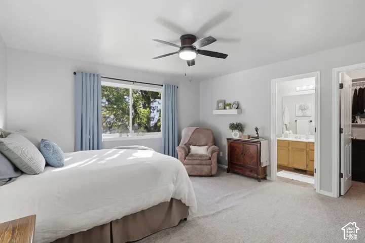 Neutral-toned carpeting, ceiling-mounted light fixture with fan, wall-mounted floating shelf, and neutral wall color palette