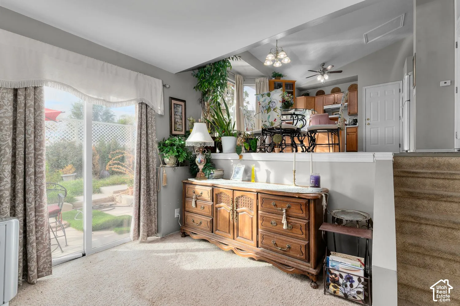 Sliding glass door, neutral carpeting, and multi-level interior layout with tiered wall ledge