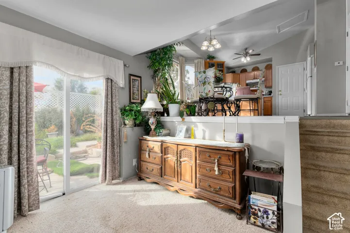 Sliding glass door, neutral carpeting, and multi-level interior layout with tiered wall ledge