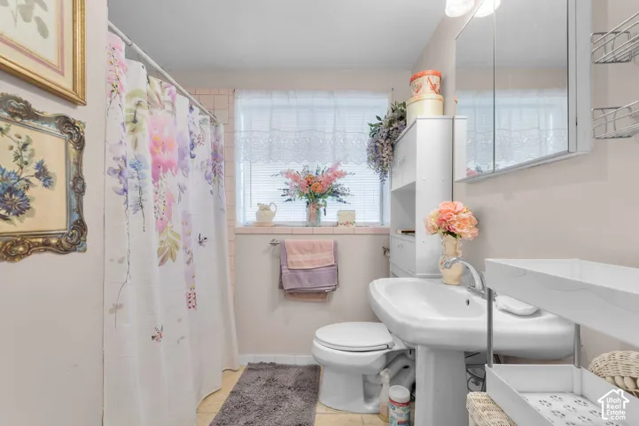 Bathroom featuring a pedestal sink, wall-mounted medicine cabinet, built-in storage cabinetry, and a bathtub with tile surround