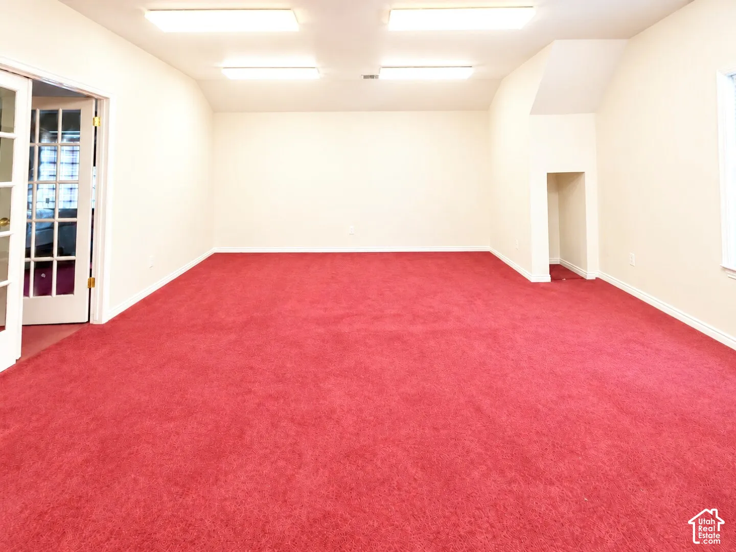 Interior space featuring wall-to-wall carpeting, recessed ceiling lighting, a built-in alcove, and a multi-pane glass door