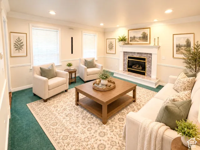 Fireplace with white mantle, stone-finish surround, crown molding, chair rail trim, and recessed ceiling lighting